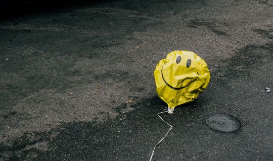 A balloon on the floor, looking a bit rough.