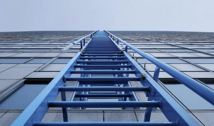 a blue ladder up a bank's head office 