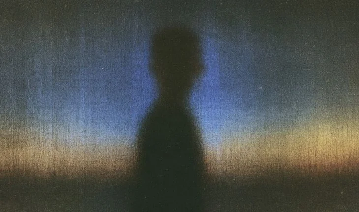 silhouette of a man against a blueish background