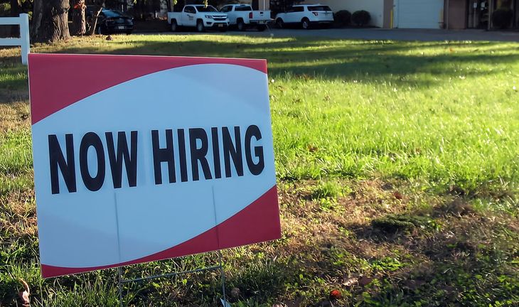a sign that says now hiring