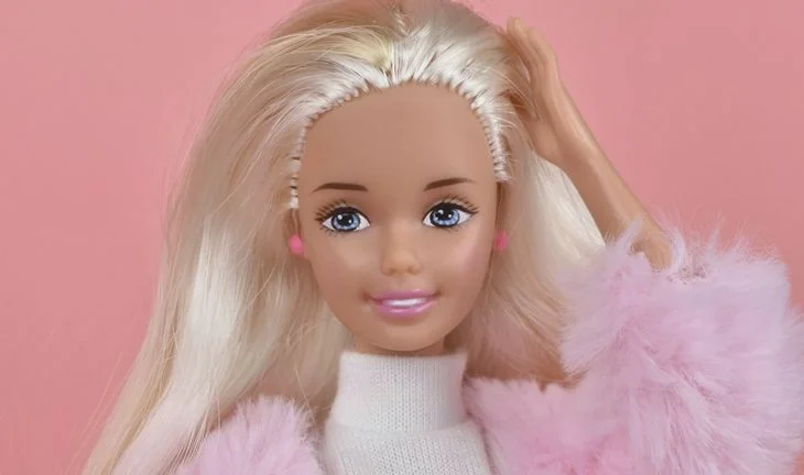 A Barbie touching her hair