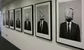 photographs on the wall of an office. The people have teabags for heads